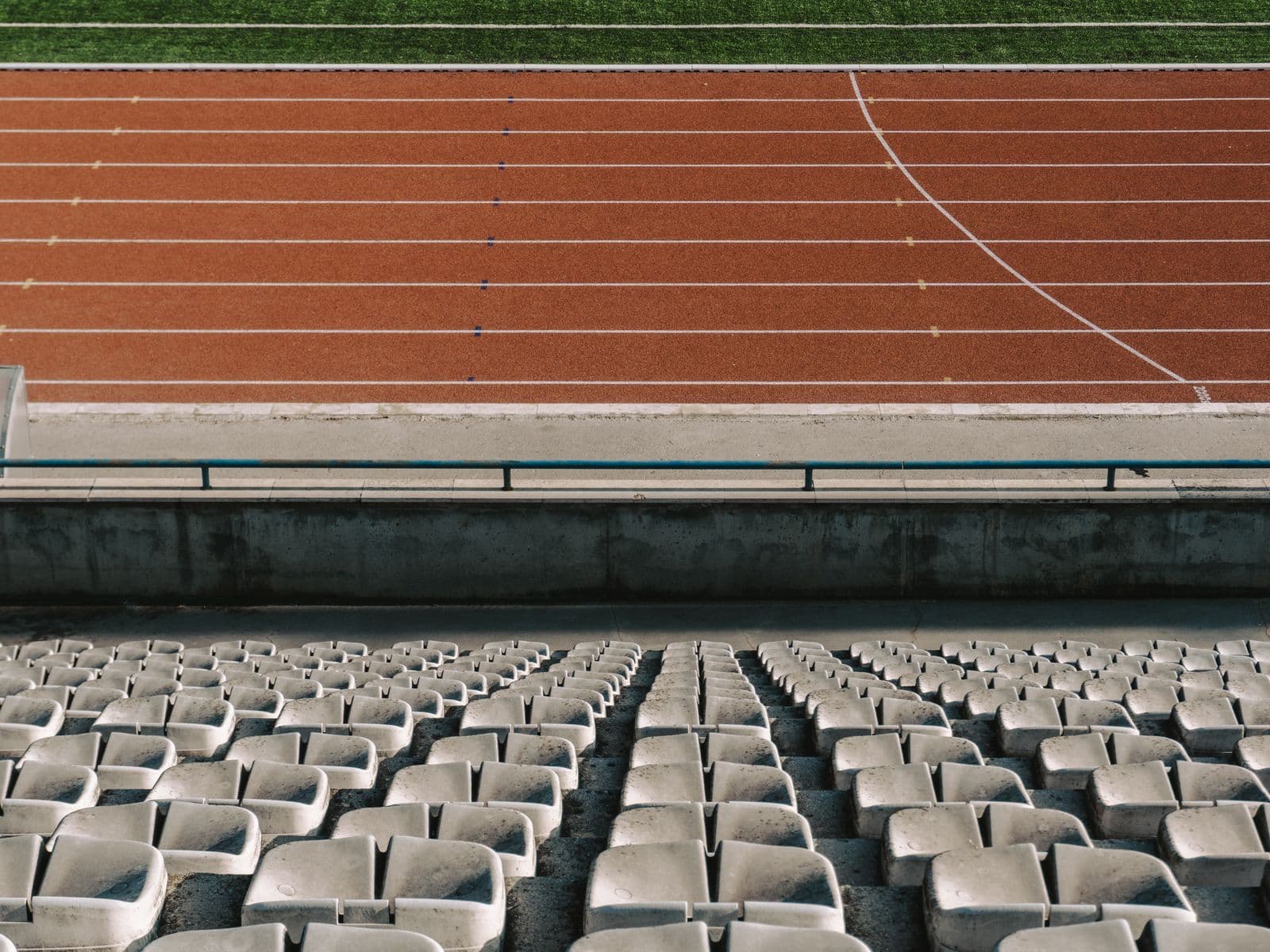 Tribuna vacía de un estadio junto a la pista de atletismo